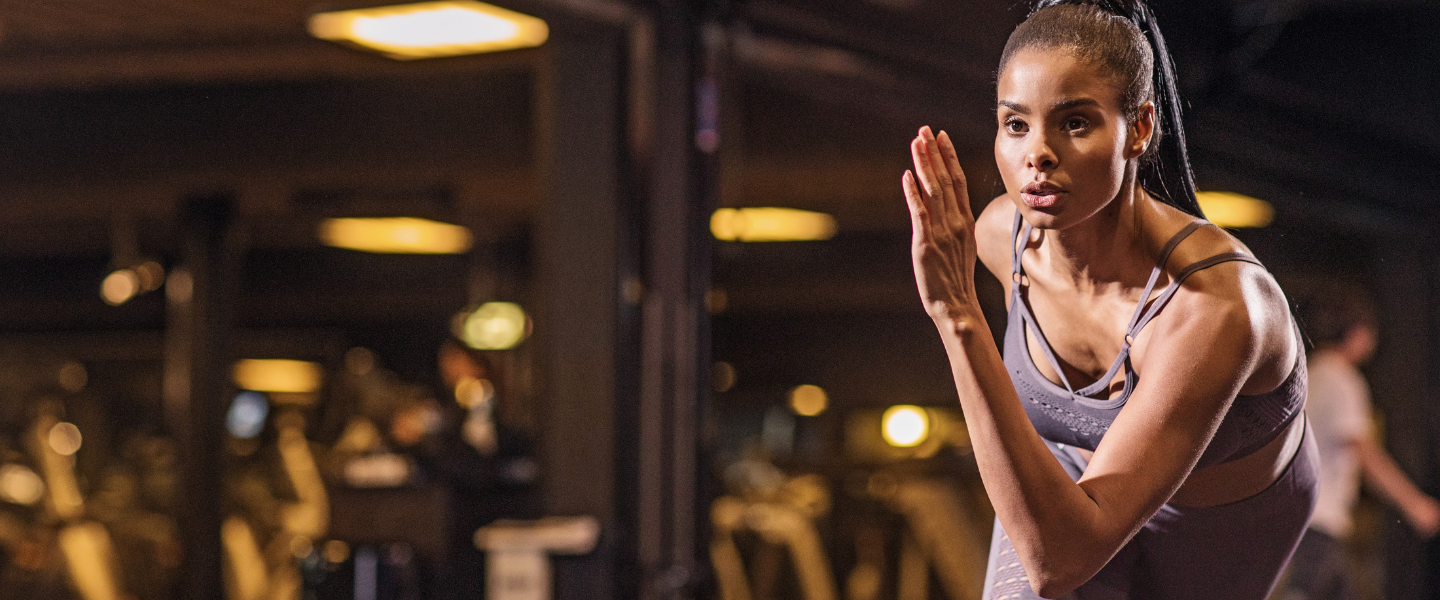 A lady is running in a building with dramatic dark lighting 